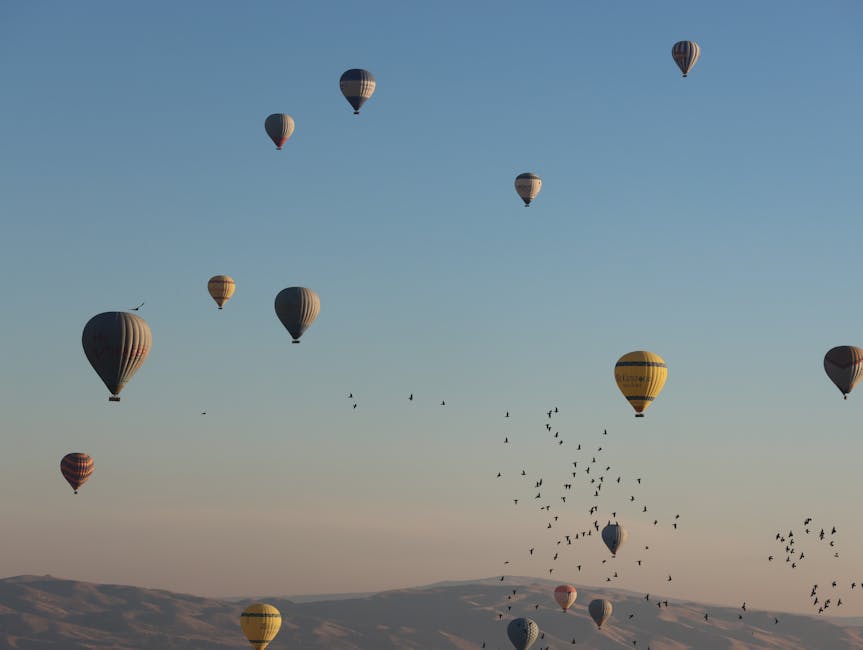 Stunning aerial view of hot air balloons floating during sunrise in Cappadocia, Türkiye.
