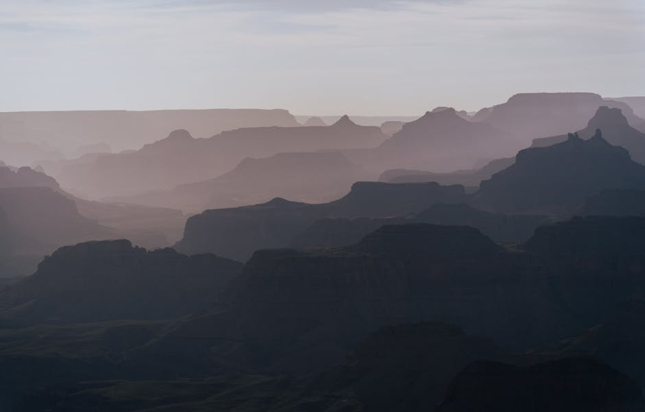 Captivating hazy sunset view of the Grand Canyon's South Rim with layered cliffs.