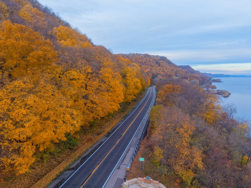 Aerial view of a vibrant autumn landscape along a winding road in Reads Landing, Minnesota by the Mississippi River.