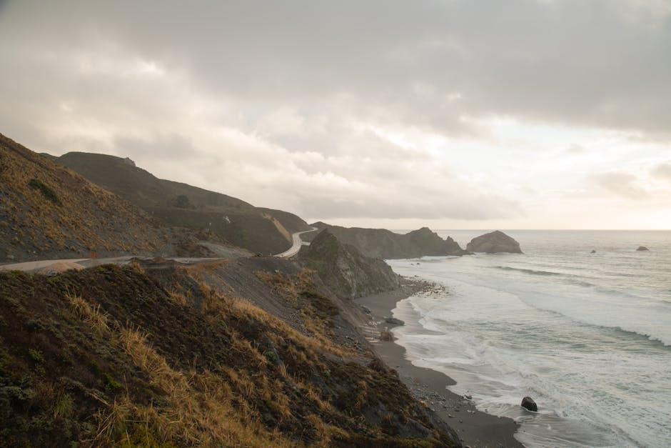 Captivating view of California's rugged coastline with waves crashing against the cliffside.