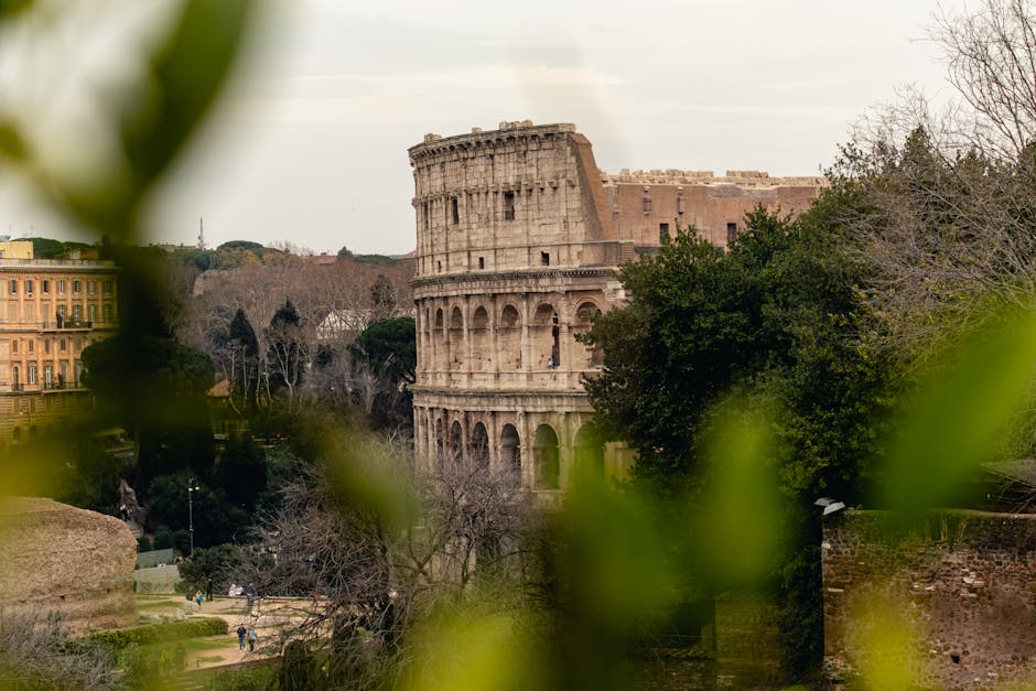 Captivating view of the Colosseum in Rome, framed by leaves, showcasing historic architecture.
