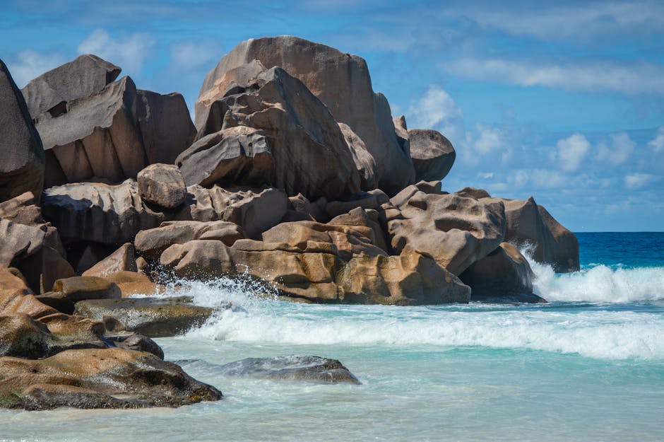 Granite rocks and turquoise waves on a sunny beach, nature escape.