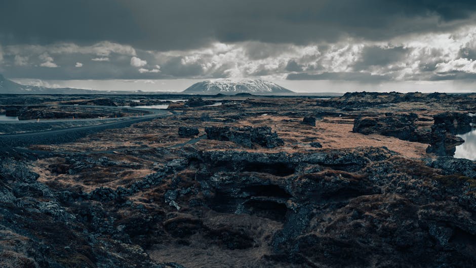 Explore Iceland's stunning volcanic terrain and distant mountains under moody skies.