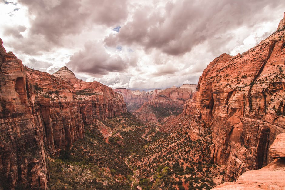 Majestic view of Zion Canyon's red rock formations under dramatic skies in Utah.
