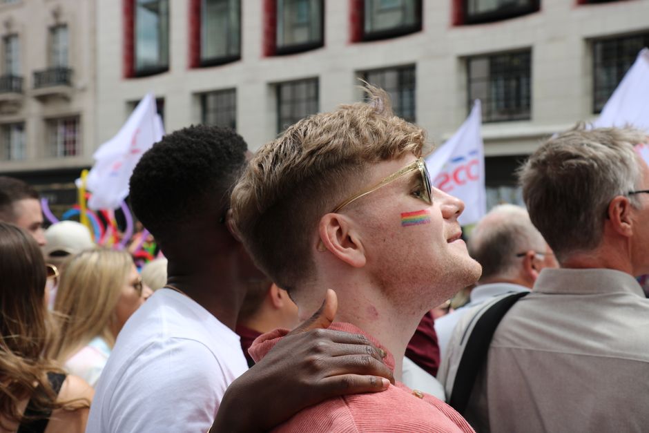 Joyful participants embrace at the vibrant London Pride Parade, showing LGBTQ pride.
