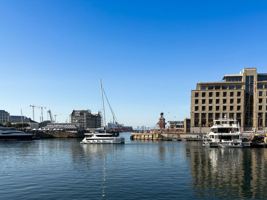 A picturesque view of a marina in Cape Town with boats and modern architecture under clear blue skies.