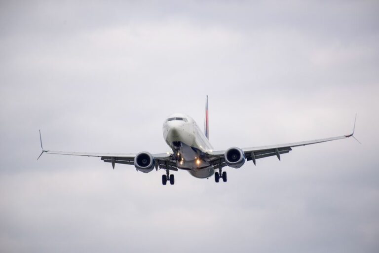 Front view of a commercial airplane approaching for landing on a cloudy day.