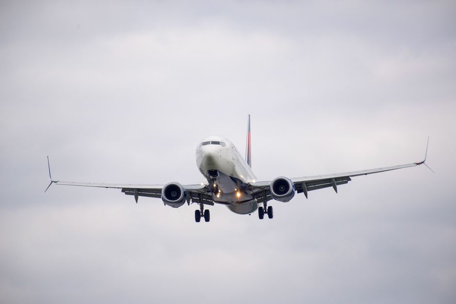Front view of a commercial airplane approaching for landing on a cloudy day.