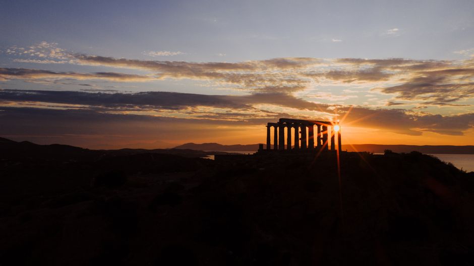 Breathtaking sunset at the Temple of Poseidon in Sounion, Greece, with vibrant skies.