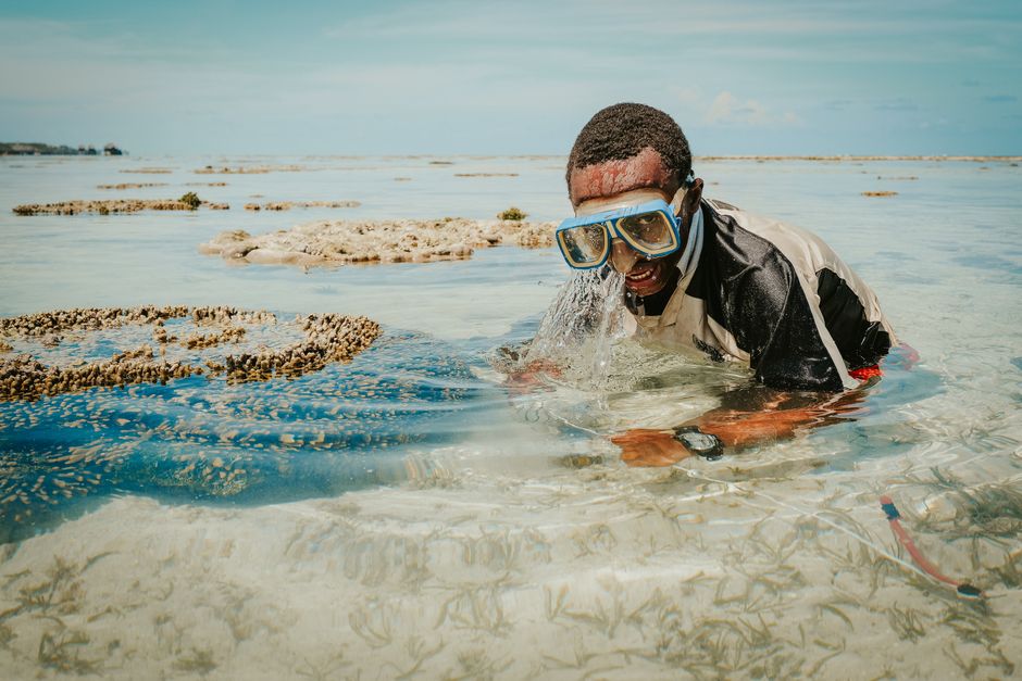 Man snorkeling in clear Zanzibar waters, capturing marine beauty.