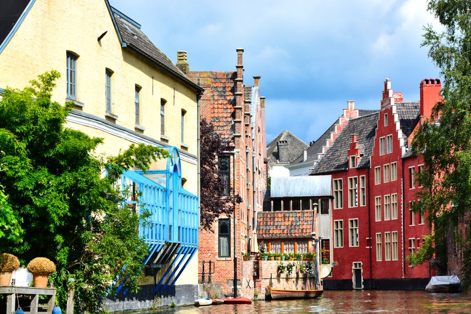 Charming canal houses with colorful facades in Ghent, Flanders, reflecting vibrant architecture.