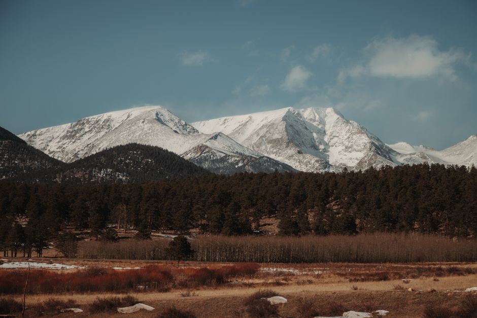 Stunning snow-covered Rocky Mountains with evergreen forest in winter landscape.
