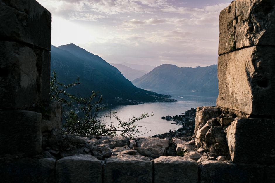 Breathtaking view of Kotor Bay from an ancient stone window at sunset, Montenegro.