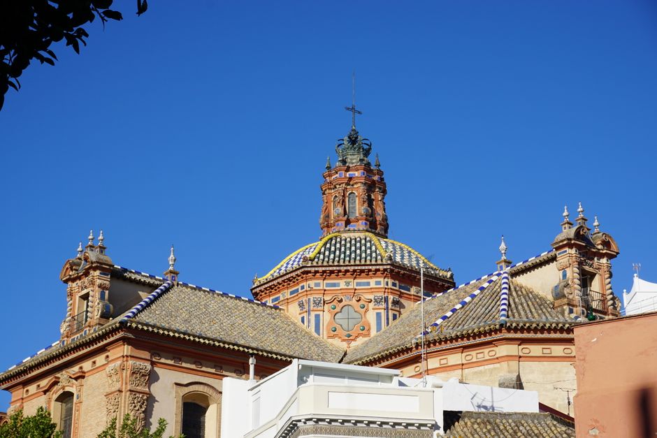 Captivating view of a historic Spanish church with detailed ornate architecture under a clear blue sky.
