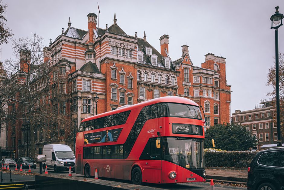 Red double-decker bus on a London street with classic architecture. Iconic British scene.