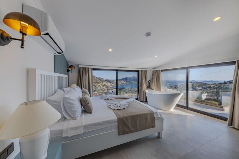 Spacious bedroom with a stunning view of the ocean, accented by contemporary design and luxury furniture.