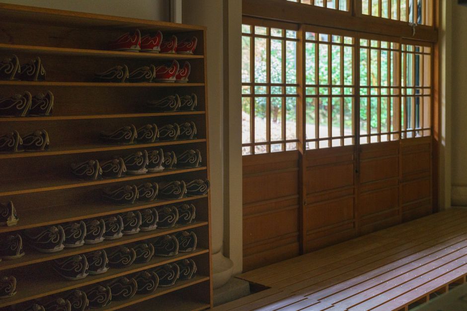 Wooden shelves with traditional Japanese footwear inside Kamakura temple.