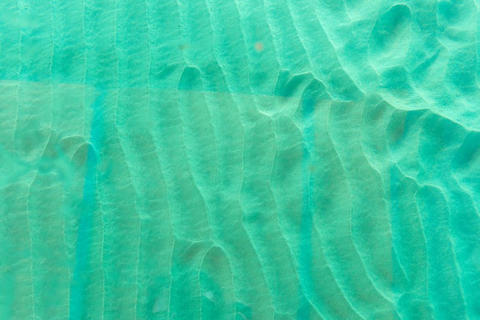 Stunning aerial view of turquoise waters and sandy seabed textures off Tobago's coast.
