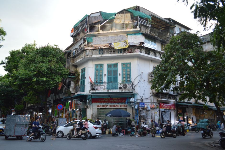 Vibrant street life in Hanoi's Old Quarter with motorbikes and shops.