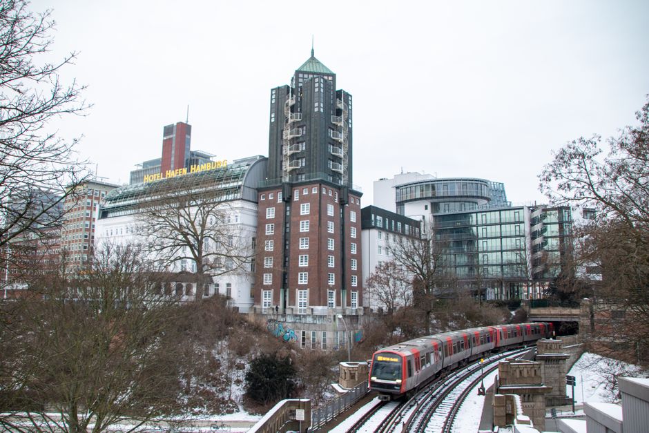 Snow-covered Hamburg with urban architecture and train in winter scene.