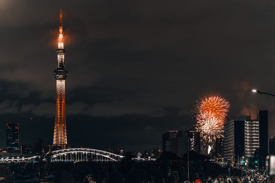Stunning night view of Tokyo Skytree and vibrant fireworks illuminating the cityscape.